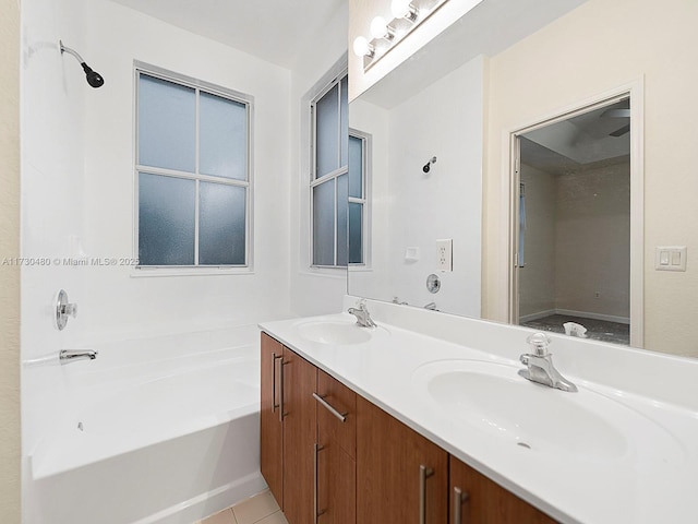 bathroom with a tub to relax in, vanity, and tile patterned flooring