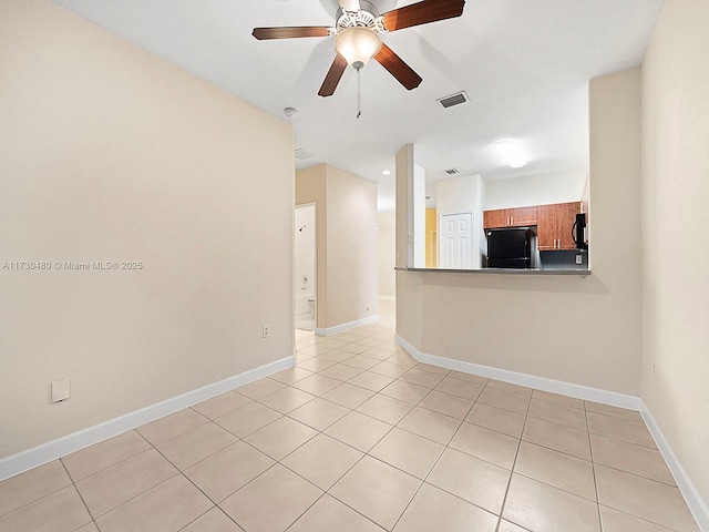 tiled empty room featuring ceiling fan