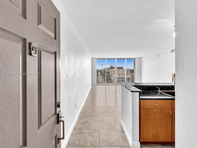 kitchen featuring light tile patterned flooring, a textured ceiling, and expansive windows