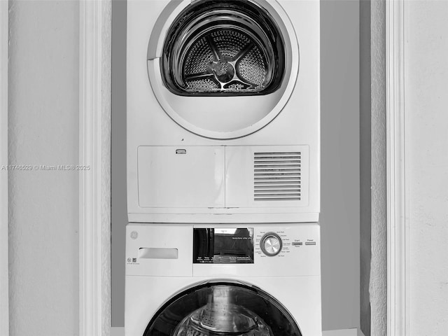 clothes washing area featuring stacked washer and clothes dryer