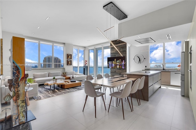 tiled dining space featuring sink and a water view