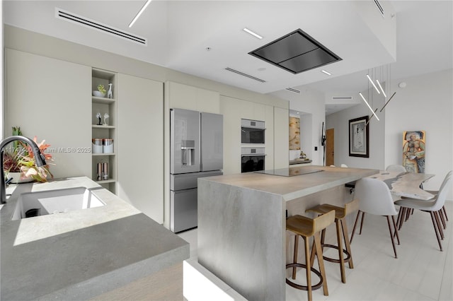 kitchen with a center island, stainless steel appliances, built in features, and sink