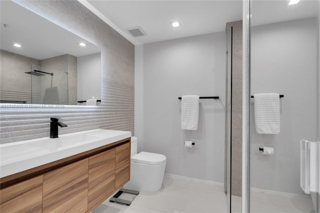 bathroom featuring vanity, a shower with shower door, and toilet