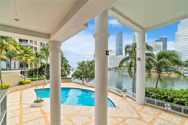 view of pool featuring a patio area and a water view