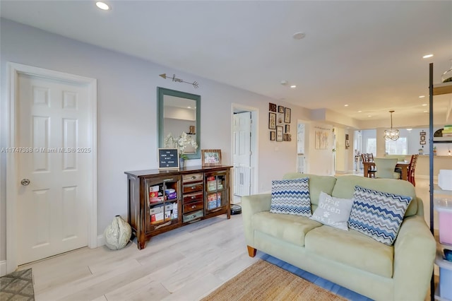 living room featuring a notable chandelier and light hardwood / wood-style flooring