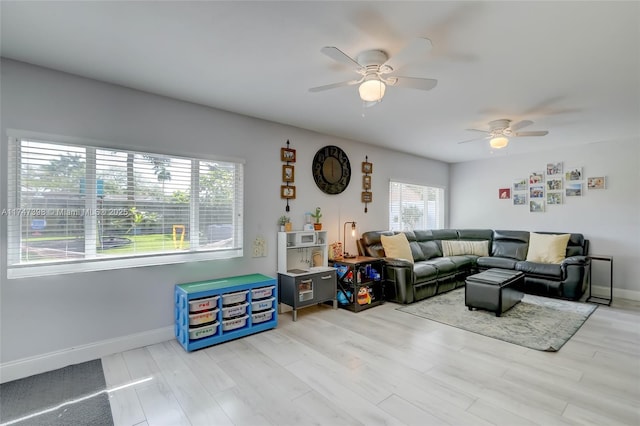 living room featuring ceiling fan and light hardwood / wood-style floors