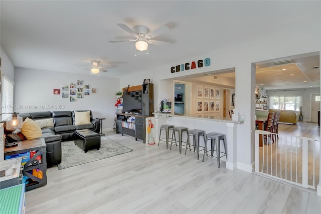 living room featuring ceiling fan and light wood-type flooring