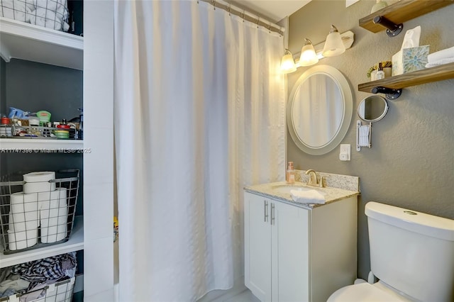 bathroom with toilet, vanity, and curtained shower