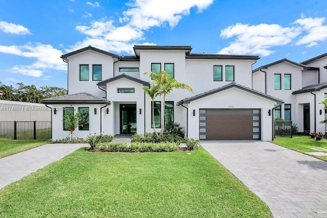 view of front of property with a front lawn, decorative driveway, and fence