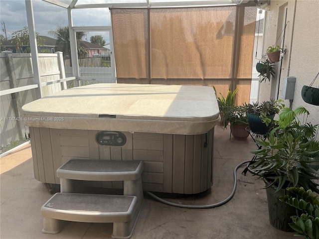 exterior space with glass enclosure, fence, and a hot tub