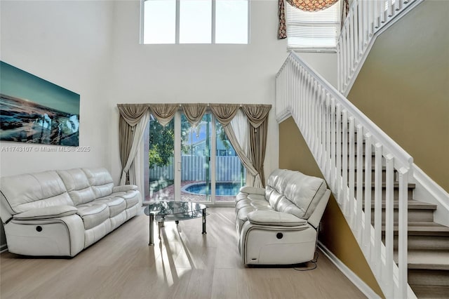 1588 SW 191st Ave, Pembroke Pines, FL 33029 - living area featuring wood finished floors, a towering ceiling, stairs, and a wealth of natural light