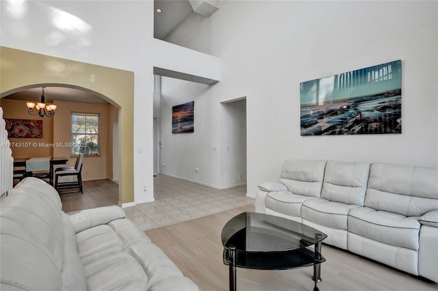 1588 SW 191st Ave, Pembroke Pines, FL 33029 - living room with arched walkways, a towering ceiling, baseboards, and an inviting chandelier