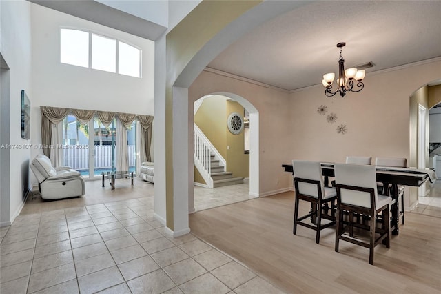 1588 SW 191st Ave, Pembroke Pines, FL 33029 - dining room featuring visible vents, arched walkways, a chandelier, stairway, and light tile patterned flooring