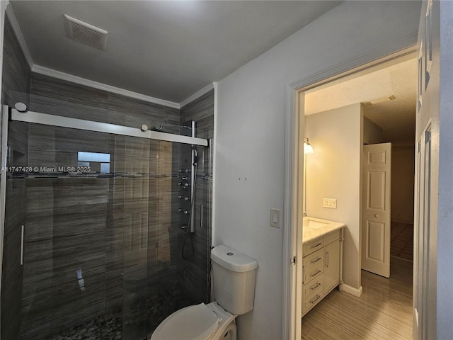 bathroom featuring an enclosed shower, toilet, vanity, hardwood / wood-style floors, and crown molding