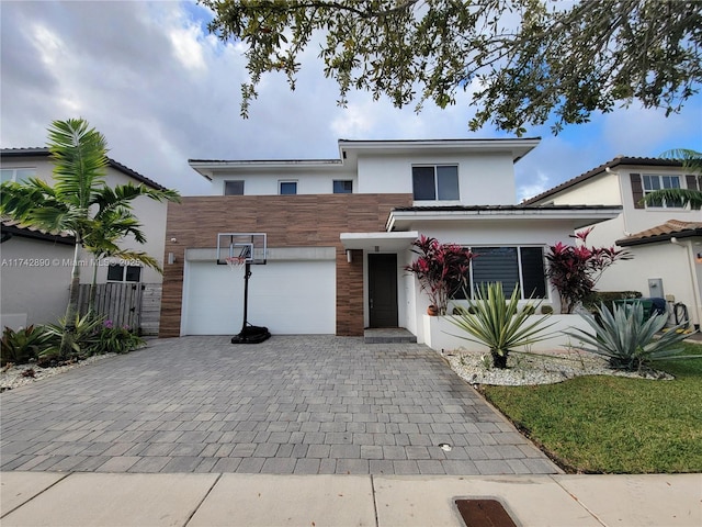 view of front facade with a garage, decorative driveway, and stucco siding