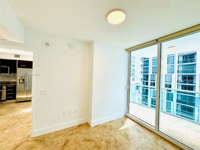 tiled spare room with floor to ceiling windows