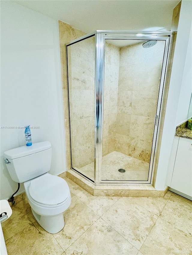 bathroom with tile patterned floors, toilet, and a shower with shower door