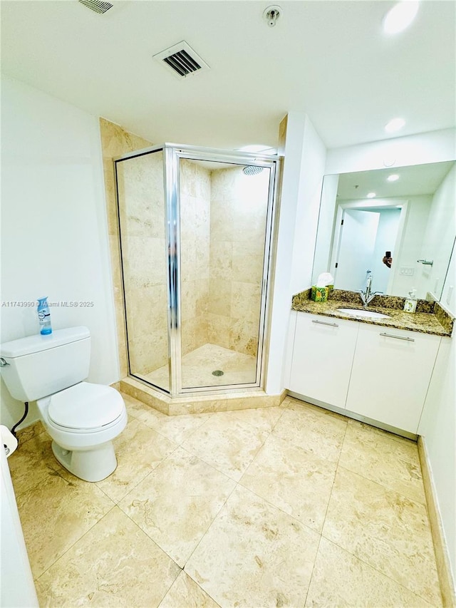 bathroom with tile patterned floors, toilet, vanity, and walk in shower