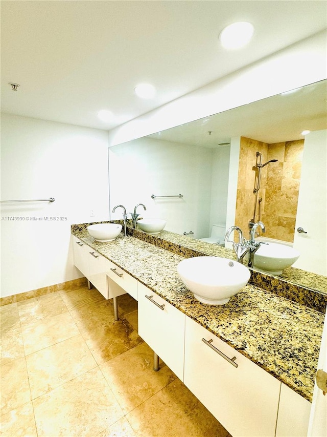 bathroom with tile patterned flooring, vanity, and a tile shower