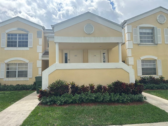 view of front facade featuring stucco siding and a front yard