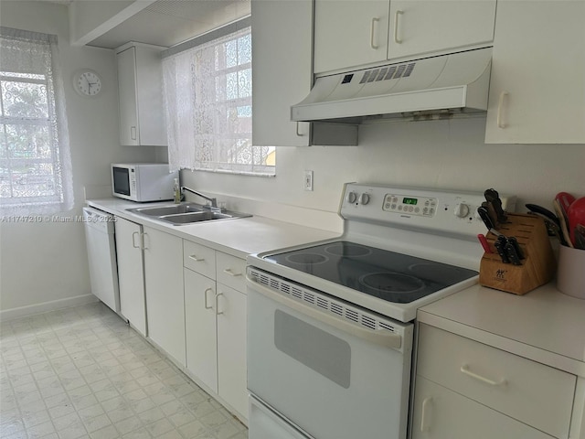 kitchen with white cabinets, under cabinet range hood, light countertops, a sink, and white appliances