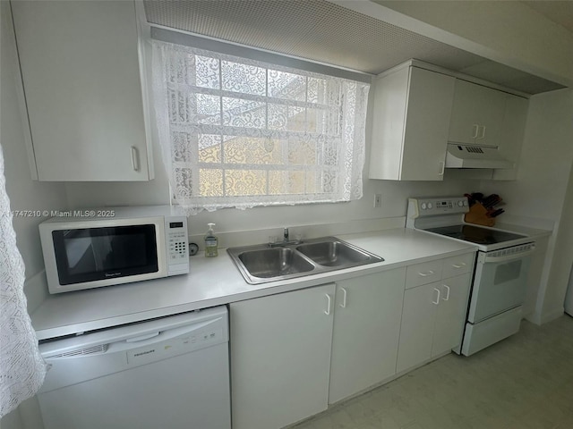 kitchen with under cabinet range hood, light countertops, white appliances, and a sink