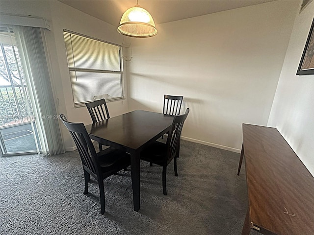 dining area featuring dark colored carpet, baseboards, and a wealth of natural light