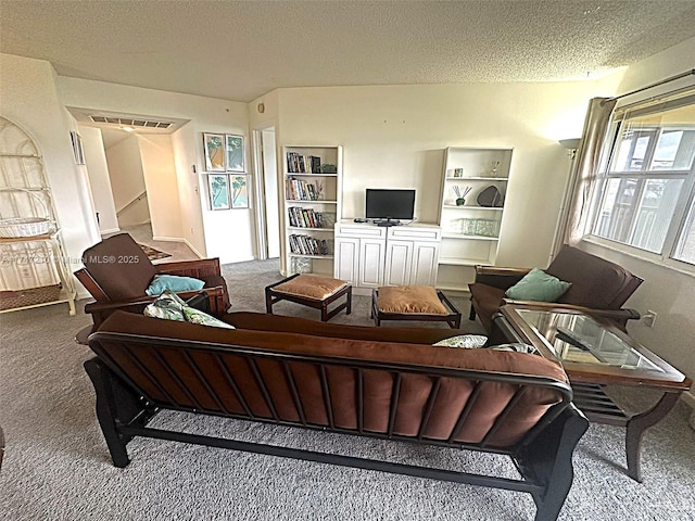 carpeted living room featuring a textured ceiling and stairs