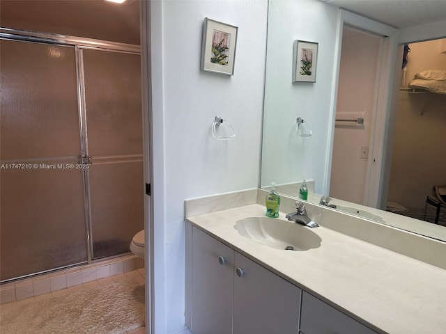 bathroom featuring vanity, tile patterned flooring, a shower stall, and toilet