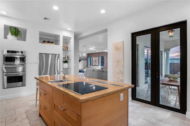 3621 S Le Jeune Rd, Miami, FL 33146 - kitchen featuring a center island with sink, sink, stainless steel appliances, and french doors