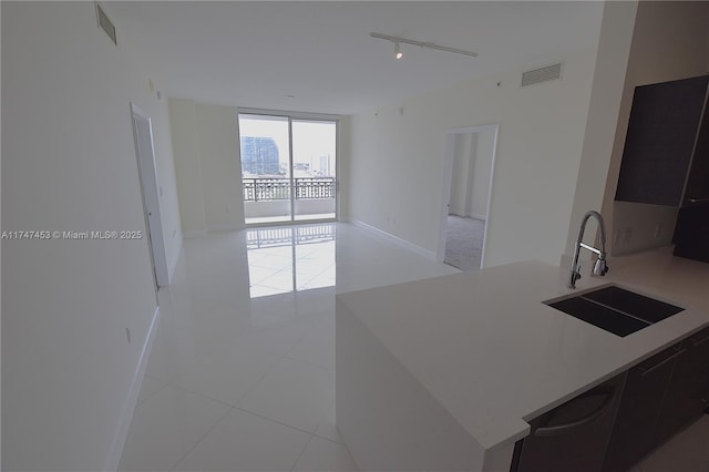 kitchen featuring light tile patterned floors, sink, rail lighting, and floor to ceiling windows