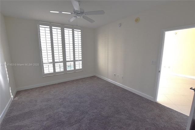 carpeted spare room featuring ceiling fan