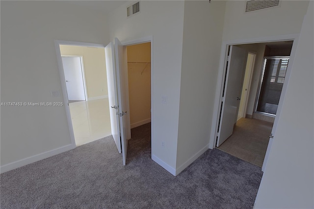 unfurnished bedroom featuring dark carpet and a towering ceiling