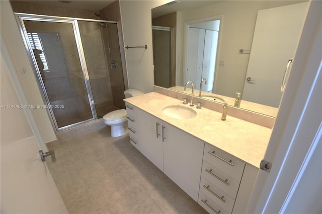 bathroom with toilet, vanity, tile patterned flooring, and a shower with door