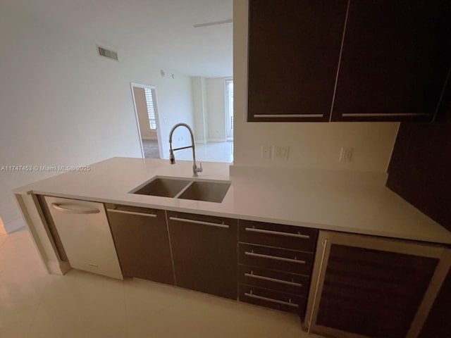 kitchen featuring sink, stainless steel dishwasher, and light tile patterned flooring