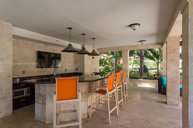 bar featuring pendant lighting and sink