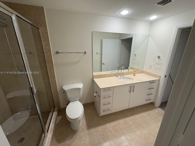 bathroom with vanity, toilet, tile patterned floors, and walk in shower