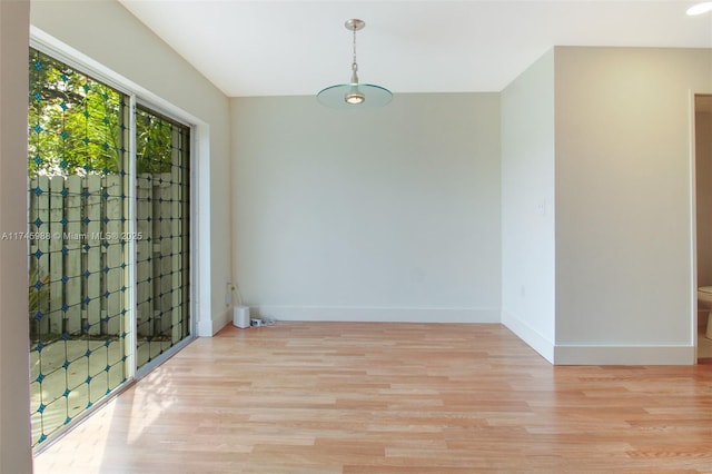 spare room featuring light wood finished floors and baseboards