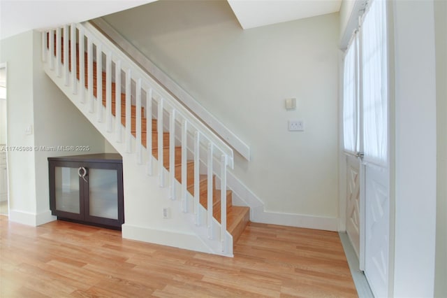 staircase with baseboards and wood finished floors