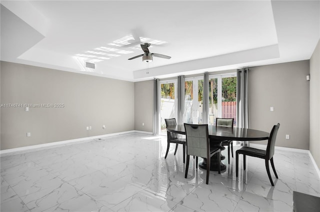 dining area featuring a tray ceiling and ceiling fan