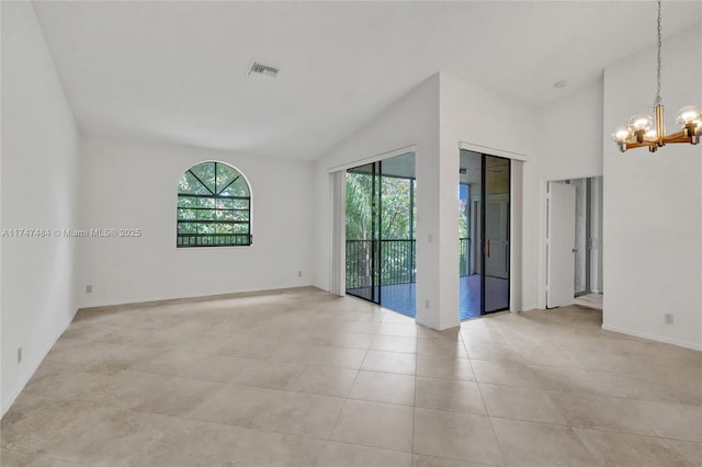 empty room featuring light tile patterned floors, a chandelier, and high vaulted ceiling