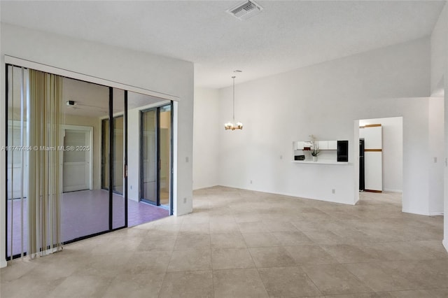 unfurnished room with an inviting chandelier