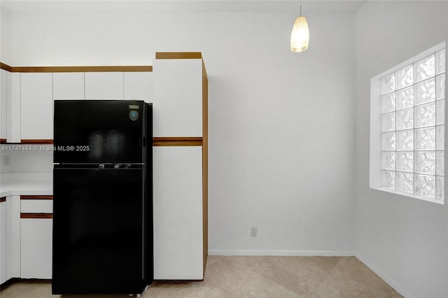 kitchen with white cabinets, pendant lighting, and black refrigerator