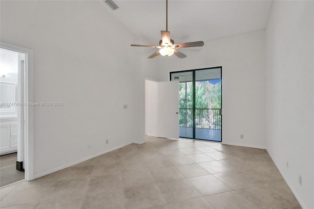 spare room featuring light tile patterned floors, ceiling fan, and a high ceiling