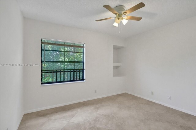 empty room featuring ceiling fan and a textured ceiling