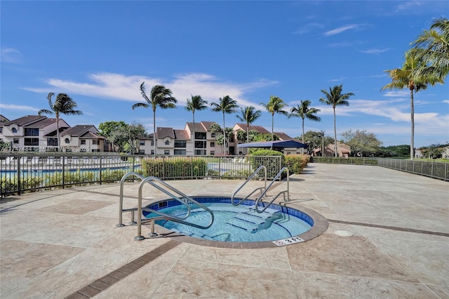 view of swimming pool with a hot tub and a patio area