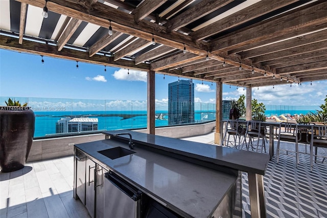 view of patio / terrace featuring a water view and a wet bar