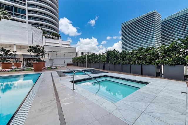 view of swimming pool with a patio and a community hot tub