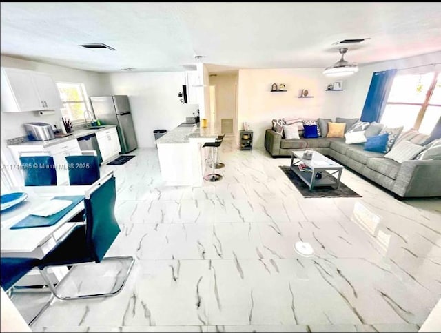 living area featuring marble finish floor and visible vents