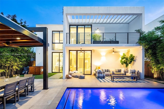 rear view of property with an outdoor hangout area, ceiling fan, a patio, and a balcony